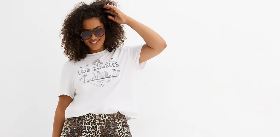 Los wit T-shirt met print, gecombineerd met een rok met panterprint. Zonnebril als accessoire.