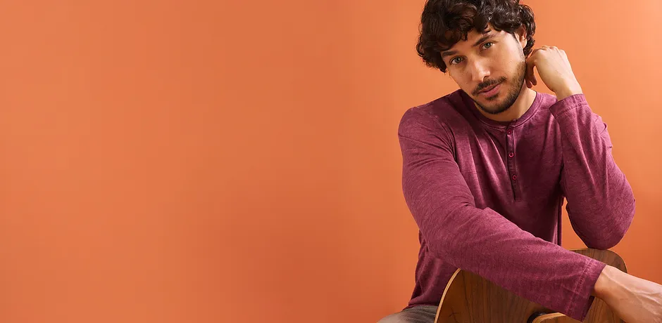 Een casual look met een bordeauxrood shirt en jeans voor het tussenseizoen.
