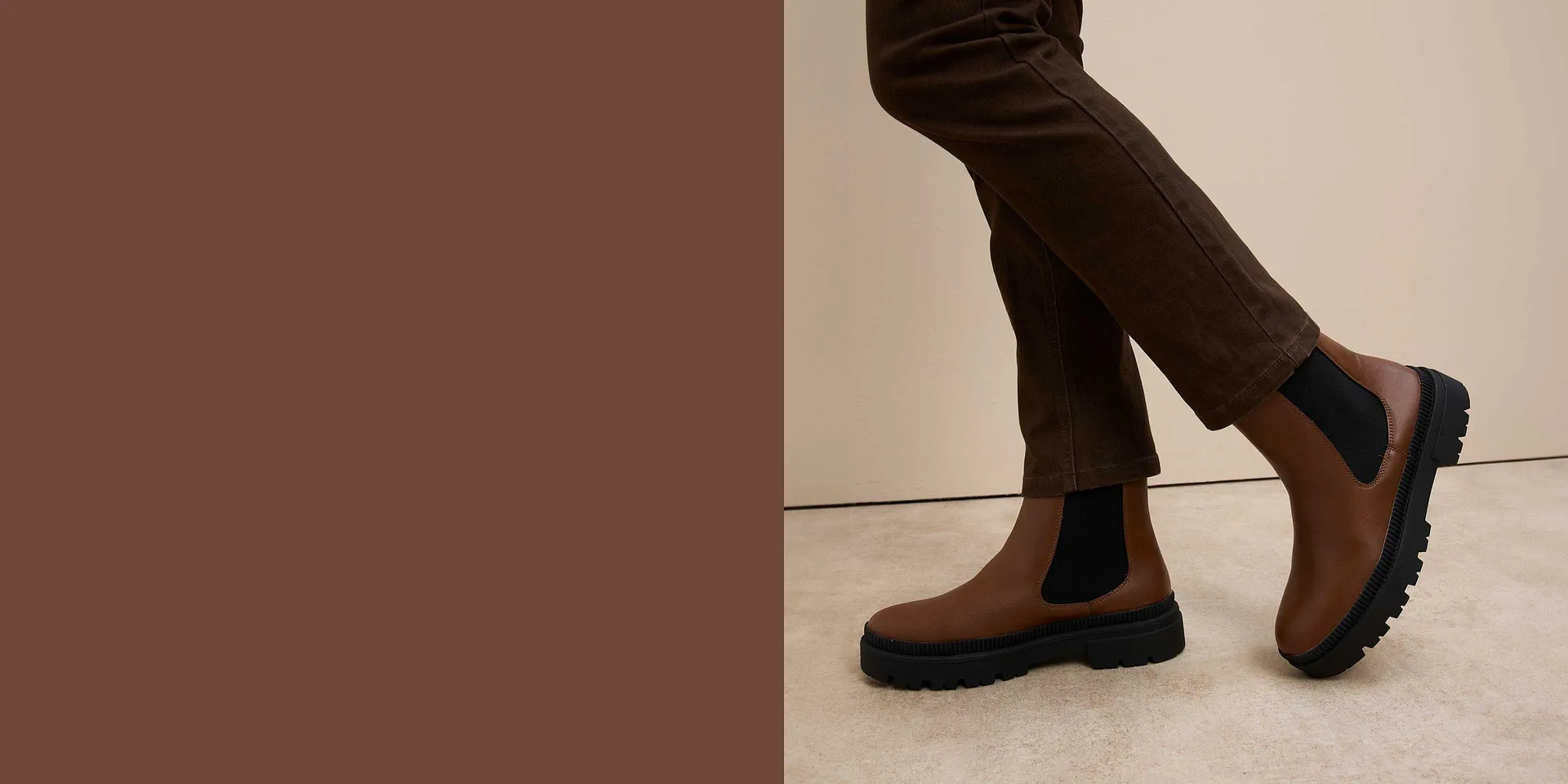 Bruine Chelsea boots met robuuste zool onder elegante broek.