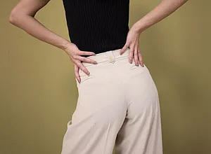 Elegante contrast: Zwart, mouwloos top met wijde, crèmekleurige broek met hoge taille.