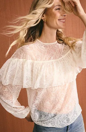 Lichte kanten blouse met ruches en lange mouwen, gecombineerd met casual jeans voor een vrouwelijke uitstraling.