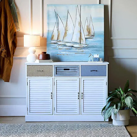 Een maritieme afbeelding op een witte commode.
