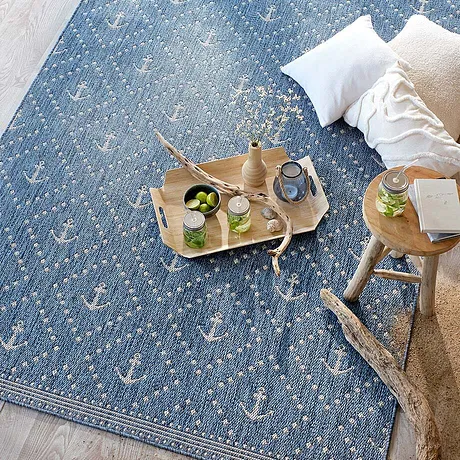Gezellig blauw tapijt met witte accenten nodigt uit om te ontspannen.