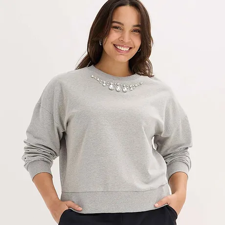 Grijs sweatshirt met fonkelende sierstenen als versiering bij de kraag.