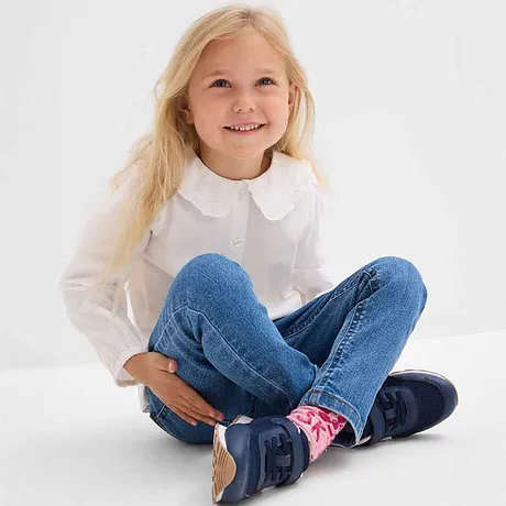 Wit overhemd met ronde kraag, blauwe spijkerbroek en donkere schoenen - casual en comfortabel.