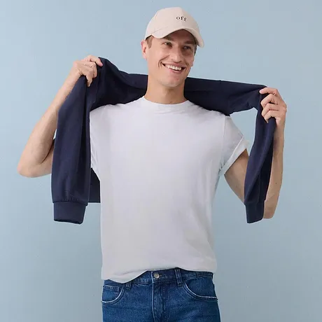 Wit T-shirt, blauwe jeans en een donker vest.