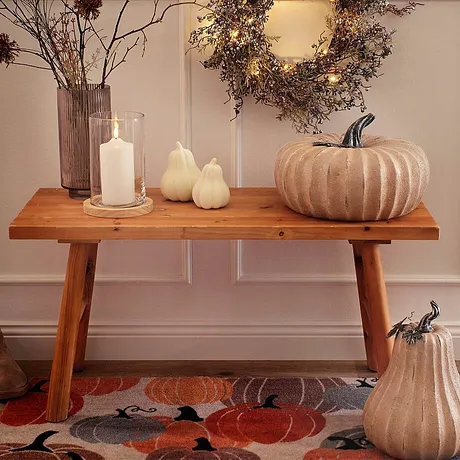 Herfstdecoratie met pompoenen en een krans, de warme kleuren en natuurlijke materialen zijn bepalend.