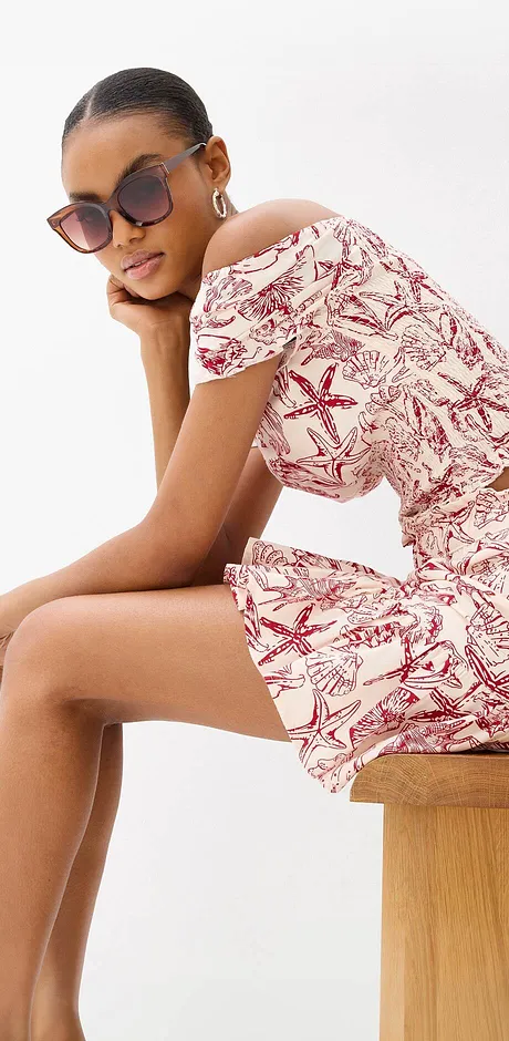Zomerse off-shoulder outfit met een dessin in rood en wit.