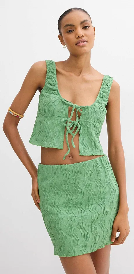 Tweedelige, gestructureerde outfit in groen bestaande uit een top en een strakke rok.