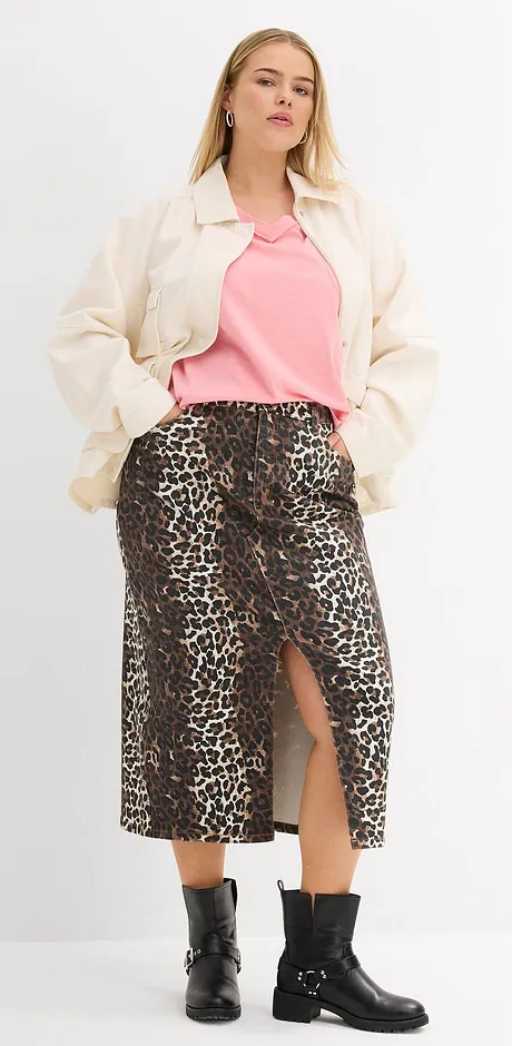 Crème kleurige jack, roze shirt, rok met panterprint en zwarte laarzen zorgen voor een stijlvolle look.