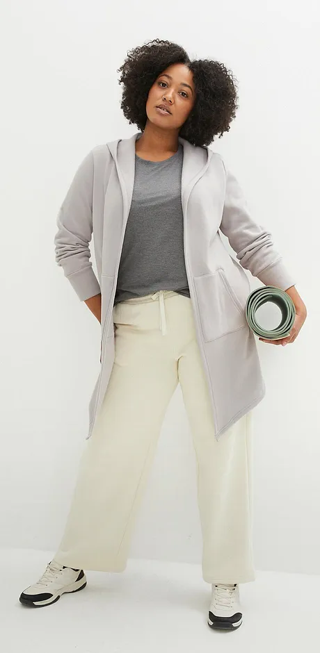 Sweatvest, shirt en creme broek voor sportieve look.