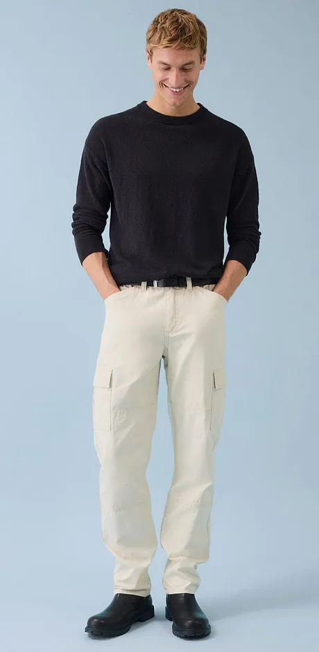 Klassieke look: een donkere trui op een lichte cargo broek.