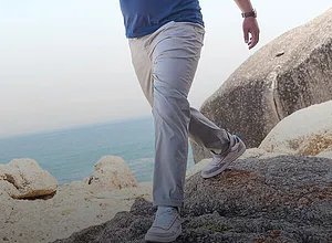 Lichtgrijze pantalon met lichte sneakers eronder.