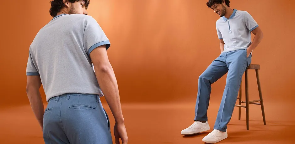 Sportief retro poloshirt in lichtblauw en een casual plooibroek in zacht lichtblauw.