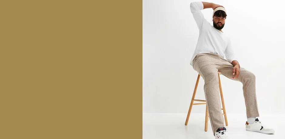 Witte longsleeve, beige broek en witte sneakers vormen een casual, stijlvolle look.