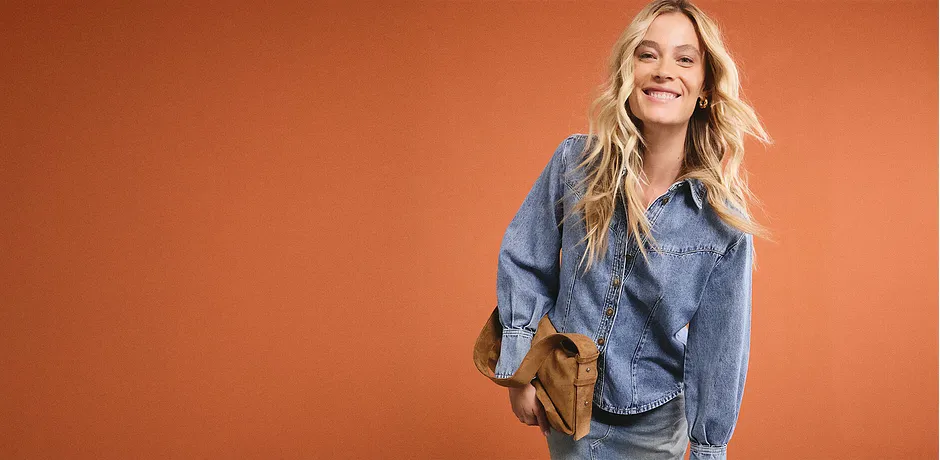 Casual denimlook met een blauwe spijkerblouse, bijpassende spijkerbroek en een bruine schoudertas voor een ontspannen dagelijkse stijl.