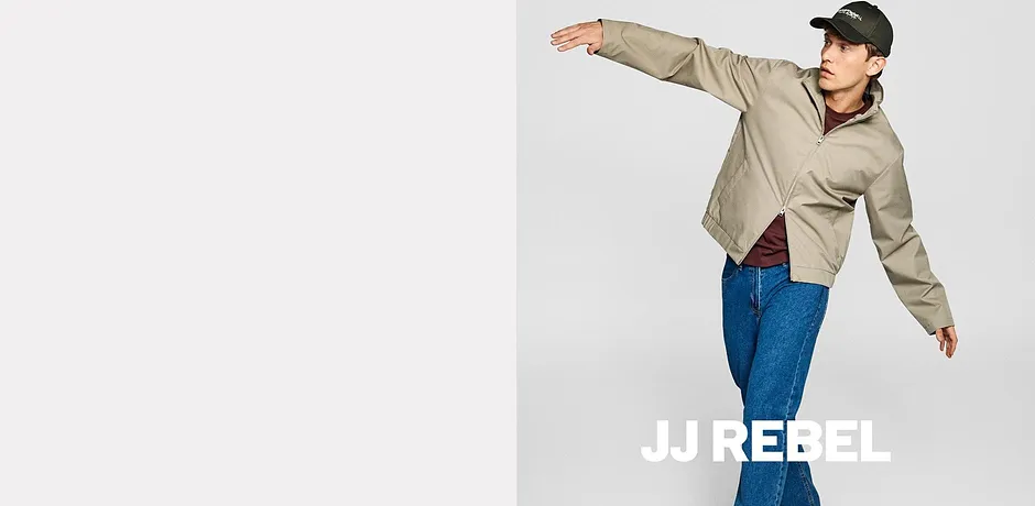 JJRebel: beige jas, blauwe jeans en een zwarte pet.